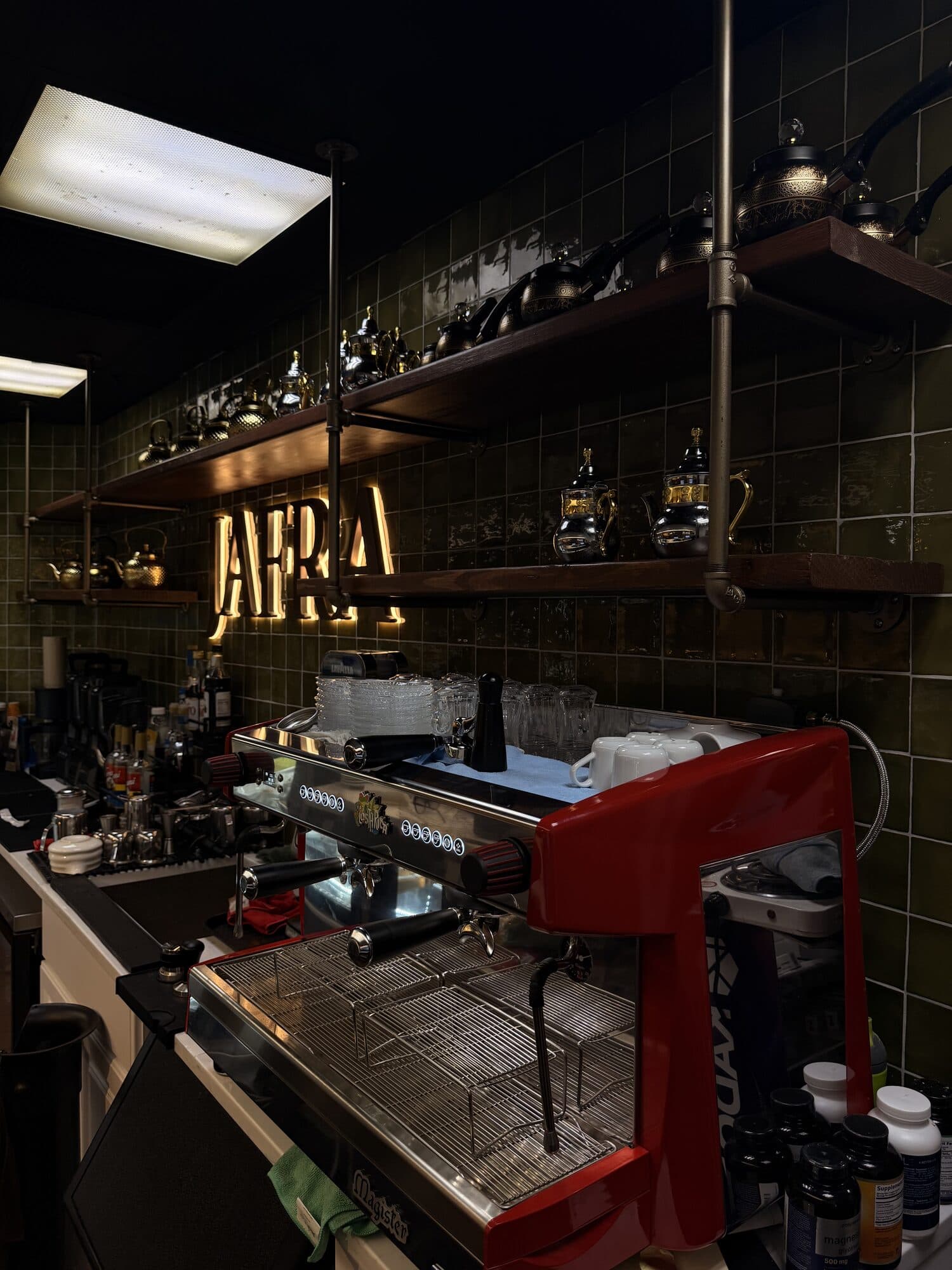 Espresso station and brass teapots beneath the JAFRA sign